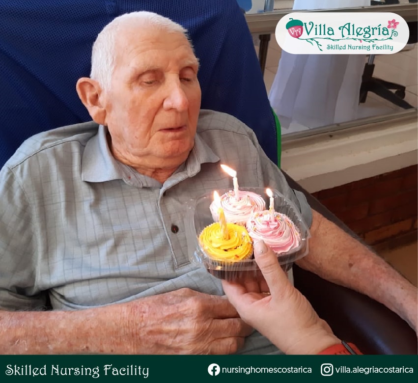 Resident Beal blowing out candles of her favorite desserts at Villa Alegría Nursing Homes, Costa Rica