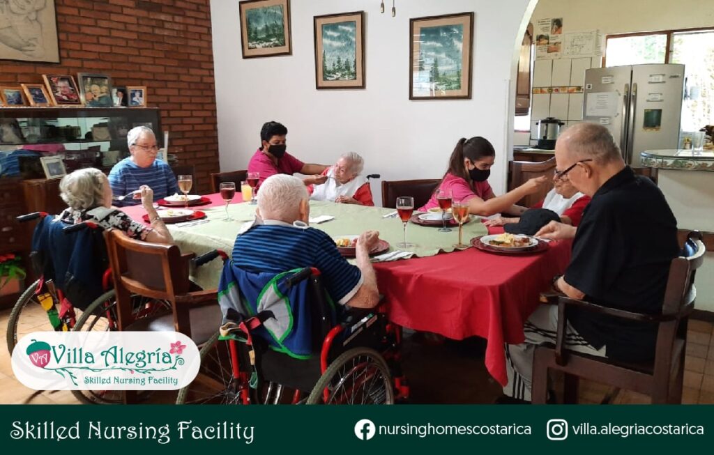 Photograph showing some of the residents of Villa Alegría having dinner.