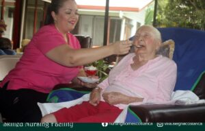 Compassionate Nurse Diana serving Gladys, a 99-year-old resident at Villa Alegría, who has Alzheimer's, her favorite dessert after a satisfying meal.