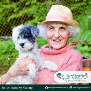 Residente Raquel con su perro camilo en terapia en Villa Alegría Nursing Homes