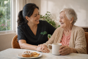 caregiver from Villa Alegría Nursing Home sharing a warm coffee moment with an elderly woman, reflecting compassionate Alzheimer care in Costa Rica.