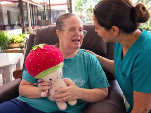Caregiver providing compassionate support to elderly woman at Villa Alegría Nursing Home in Costa Rica
