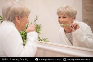 Elderly woman practicing dental care by brushing her teeth - Dental Care for Older Adults