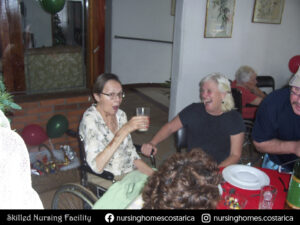 Residents enjoying a gathering at Villa Alegría, sharing a meal and laughing together.
