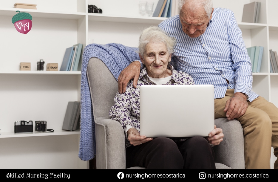 Senior couple sitting together, using a computer and embracing the digital age with enthusiasm and connection.