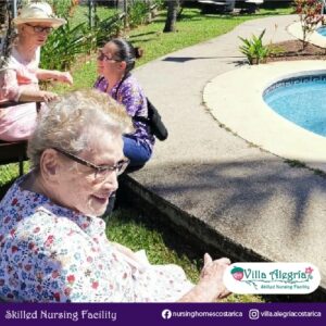 Resident Zoraida and Ann enjoying the sun by the pool with assistant Mary