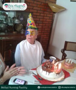 Dorothy usando un antifaz y posando frente a su pastel de cumpleaños