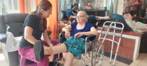 Physical therapist assisting an elderly woman during a mobility and strength