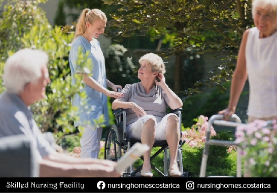 Residents and caregiver enjoying a peaceful moment in the garden at Villa Alegría.